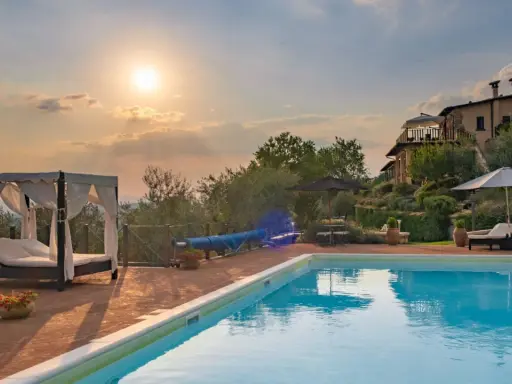 Piscina e lettini in una delle splendide tenute in Toscana al tramonto.