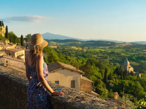 Donna con cappello ammira il panorama collinare toscano, perfetto per scoprire cosa visitare in Toscana in 2 giorni.