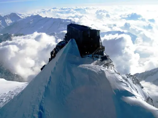 Il rifugio più alto d'Italia, incastonato su una vetta innevata, domina un mare di nuvole.