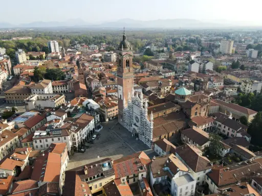 Vista aerea della Duomo di Monza, con la sua facciata a strisce bianche e nere. Si vede il campanile e il centro storico, che mostra dove si trova Monza.