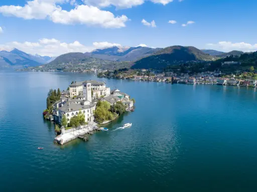 Isola di San Giulio, una gemma nel lago d'Orta, con la città sul mare nord Italia sullo sfondo.