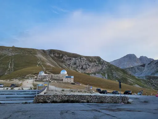 Osservatorio astronomico sul Gran Sasso, con montagne imponenti sullo sfondo. Un luogo ideale per gli alpinisti che amano la natura e il cielo stellato.