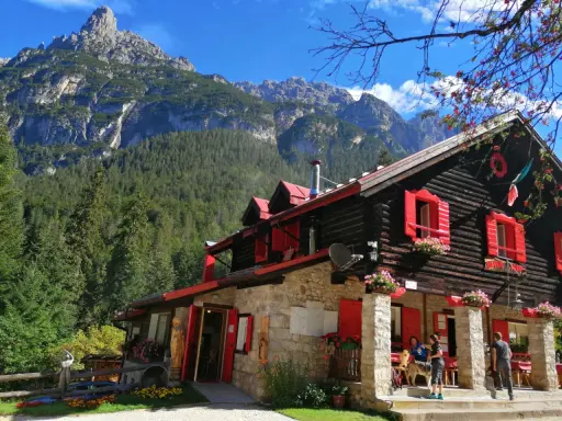 Rifugio con forni di sopra, circondato da boschi e montagne imponenti.