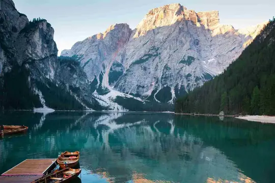 Verona è lontana, ma il Lago di Braies offre uno spettacolo mozzafiato con montagne imponenti e barche di legno che galleggiano su acque cristalline.