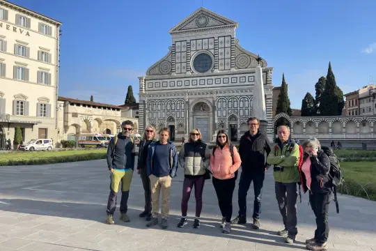 Un gruppo di escursionisti posa davanti alla Basilica di Santa Maria Novella, un'icona lungo la Via Romea Sanese.