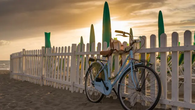 Bicicletta azzurra sulla spiaggia di Forte dei Marmi al tramonto, un'idea per cosa vedere a Forte dei Marmi in un giorno.