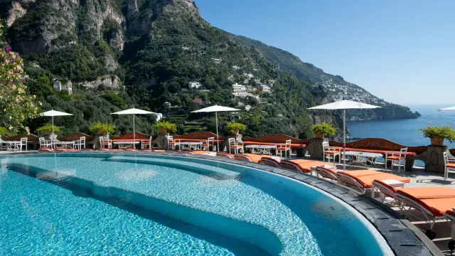 Piscina panoramica con vista sui **paesi più belli della Costiera Amalfitana**. Terrazza con lettini, ombrelloni e tavolini.