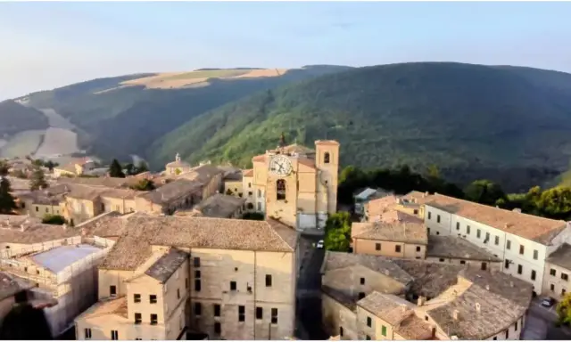 Borgo con torre dell'orologio, immerso nel verde delle colline. Chissà se è questo il borgo dei borghi vincitore.