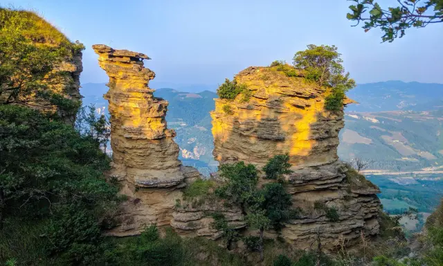 Formazioni rocciose suggestive illuminate dal sole, un paesaggio mozzafiato che ricorda le tappe del cammino della Via degli Dei.
