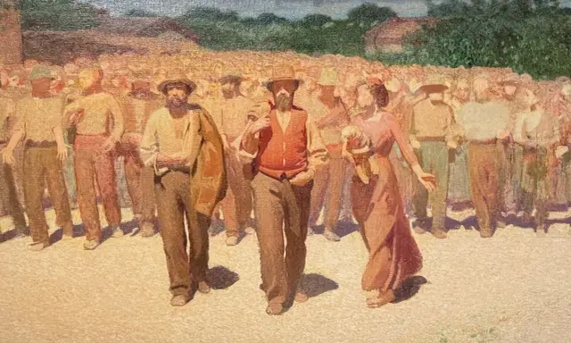 Un corteo di persone in abiti da lavoro, con un uomo in primo piano con gilet arancione. Un'immagine che evoca la vita e le tradizioni di Volpedo cosa vedere.