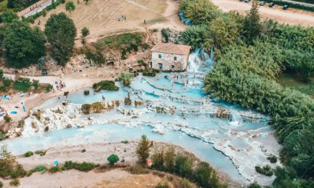 Una perfetta gita domenicale toscana: cascate termali azzurre e gente che si rilassa tra le rocce.