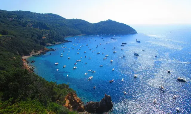 Cala Grande Argentario: un paradiso azzurro con barche. Per arrivare, goditi questo panorama mozzafiato.