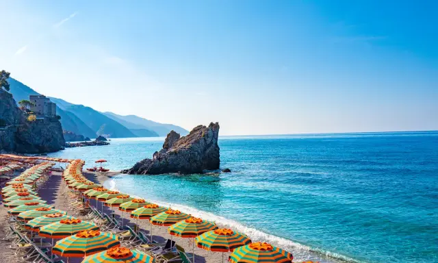 Spiaggia con ombrelloni colorati e mare cristallino, un angolo di paradiso, il mare più vicino a Milano.