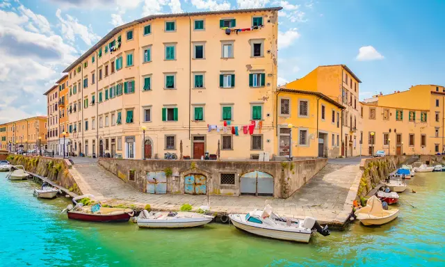 Canali di Livorno, un'idea per cosa vedere a Livorno in un giorno. Case colorate e barche sull'acqua turchese.