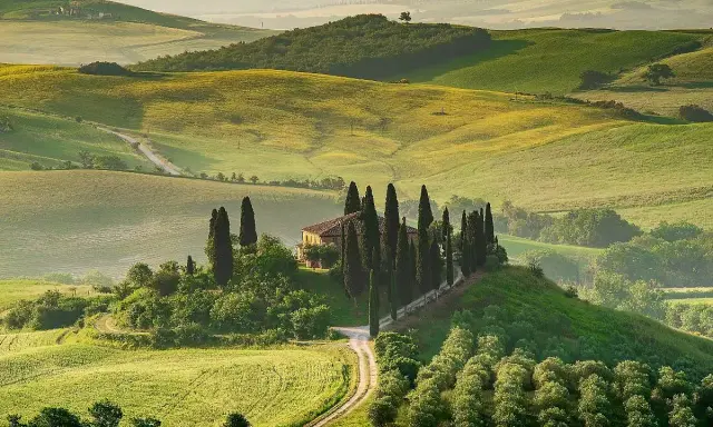 Colline toscane con cipressi e casale, un'immagine iconica dei borghi da visitare in Toscana.
