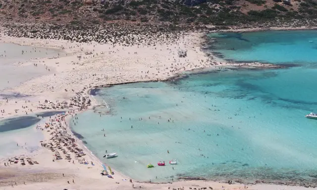 Spiaggia affollata con acque turchesi, ideale per chi cerca dove andare al mare a novembre.