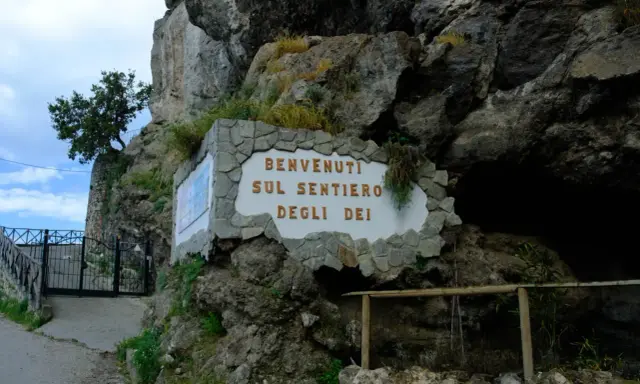Ingresso del Sentiero degli Dei, con cartello di benvenuto e cancello in ferro battuto.