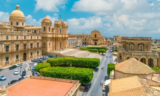 Vista aerea di un noto borgo della costiera amalfitana, con chiese barocche, piazze e strade animate.