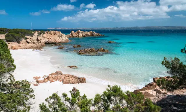 Spiaggia bianca, rocce rosse e mare cristallino: un sogno per chi cerca dove andare al mare a settembre spendendo poco.