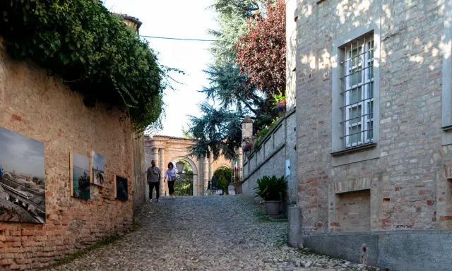 Passeggiata nel centro storico di Neive, tra antiche mura ricoperte d'edera e opere d'arte esposte all'aperto.