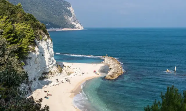 Spiaggia dorata con scogliere bianche e mare cristallino, un angolo di paradiso tra le migliori spiagge del nord Italia.