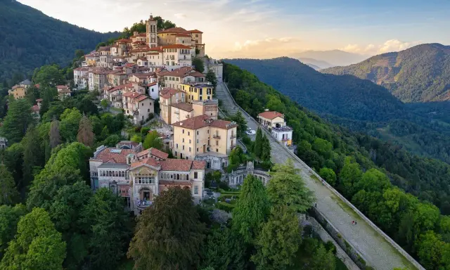 Borgo pittoresco su un colle, ideale per scoprire cose da fare a Varese. Case colorate, un campanile e sentieri panoramici tra il verde.