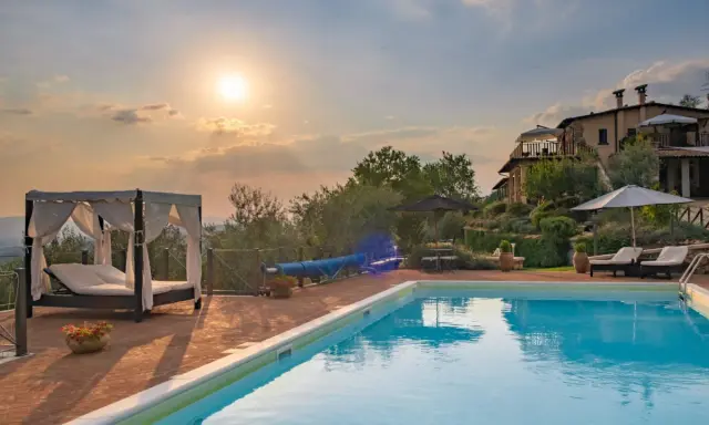 Piscina e lettini in una delle splendide tenute in Toscana al tramonto.