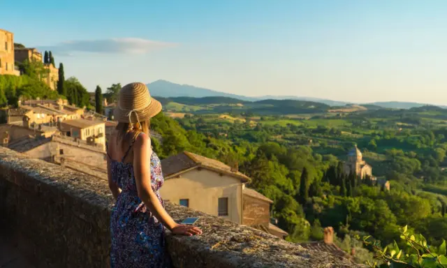 Donna con cappello ammira il panorama collinare toscano, perfetto per scoprire cosa visitare in Toscana in 2 giorni.