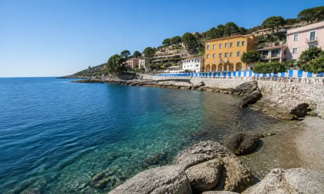 Acque cristalline e case colorate lungo la costa, un angolo di paradiso tra le calette di Porto Santo Stefano.