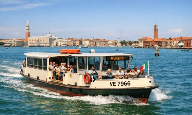 Barca con passeggeri diretta a Murano, con Venezia sullo sfondo. Un modo semplice per capire come arrivare a Murano da Venezia.