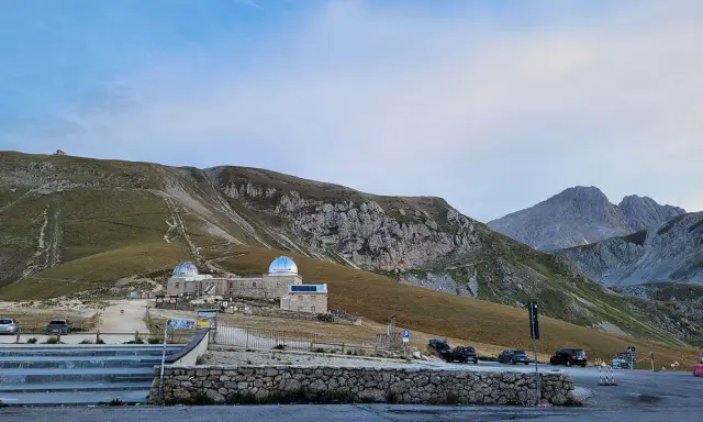Osservatorio astronomico sul Gran Sasso, con montagne imponenti sullo sfondo. Un luogo ideale per gli alpinisti che amano la natura e il cielo stellato.