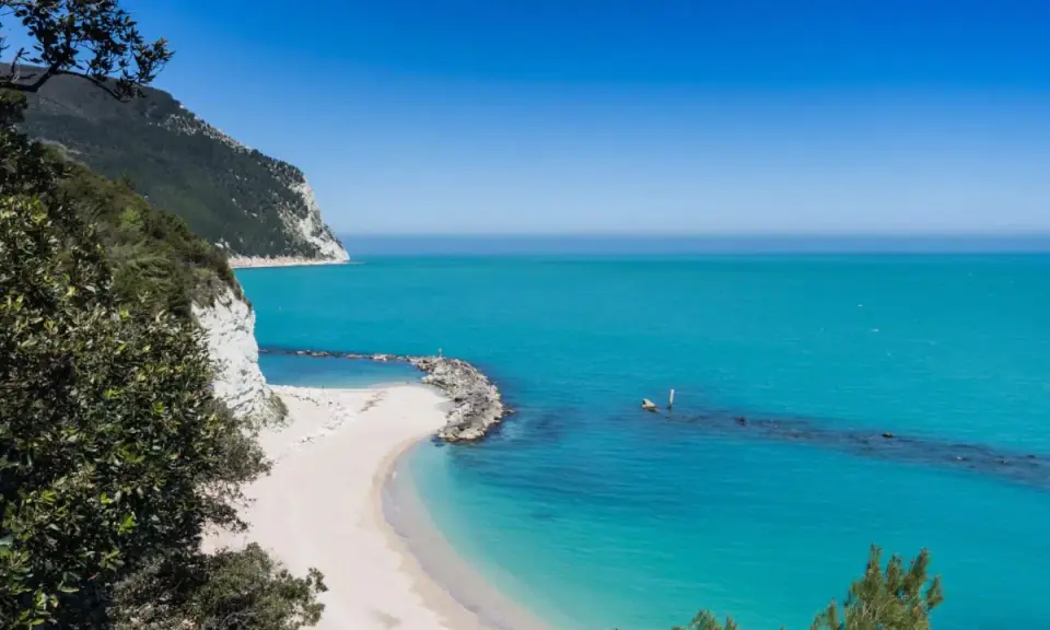 Spiagge piu belle d'Italia: una caletta di sabbia bianca incastonata tra scogliere a picco e un mare turchese cristallino.