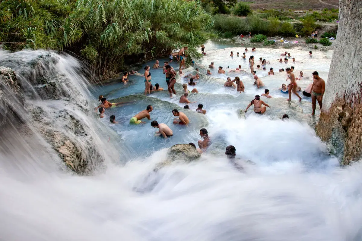 Cascate naturali con persone che si bagnano, un luogo incantevole dove si trovano le terme di Saturnia.