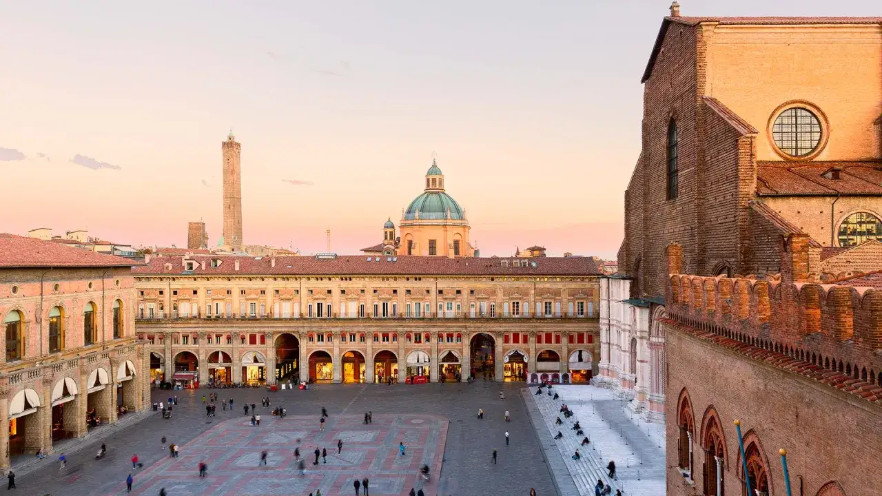 Piazza Maggiore a Bologna, una delle citt&agrave; pi&ugrave; belle dell'Emilia Romagna, con le torri e la cupola al tramonto.
