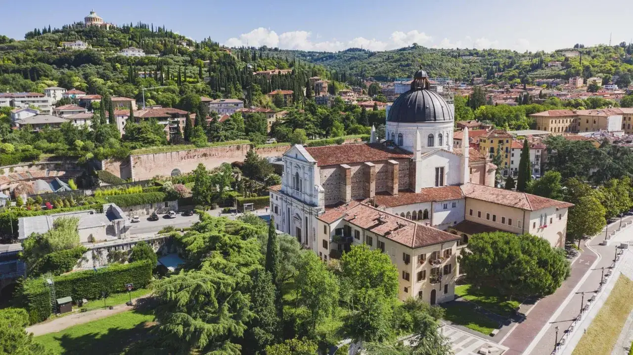 Vista aerea di San Giorgio in Valpolicella, Verona, con la chiesa imponente e le colline verdi sullo sfondo.