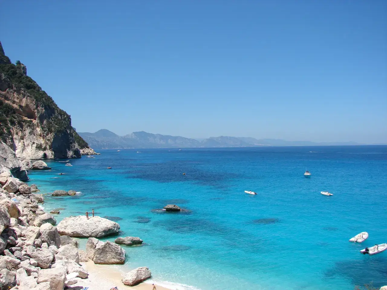 Scogliere rocciose e acque cristalline, un paradiso tra le spiagge più belle Sardegna est. Barche a vela e un mare turchese invitano al relax.