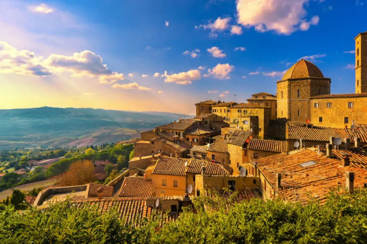 Panoramica di Volterra, dove si trova questo borgo medievale toscano, con i suoi tetti in cotto e il cielo azzurro.