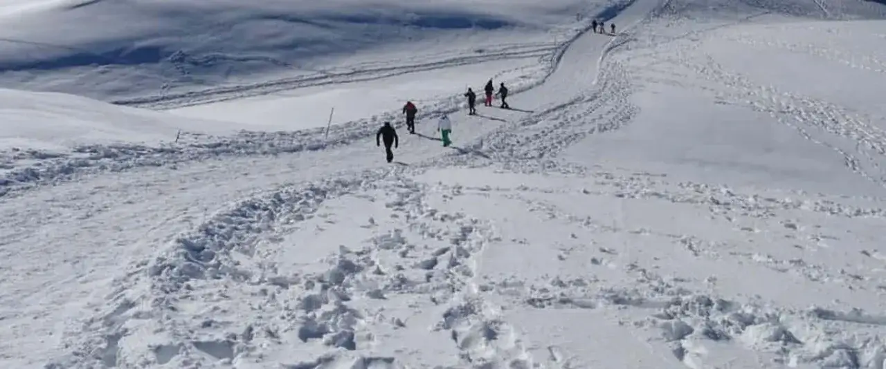 Persone camminano su un sentiero innevato, godendosi le escursioni invernali in Trentino.