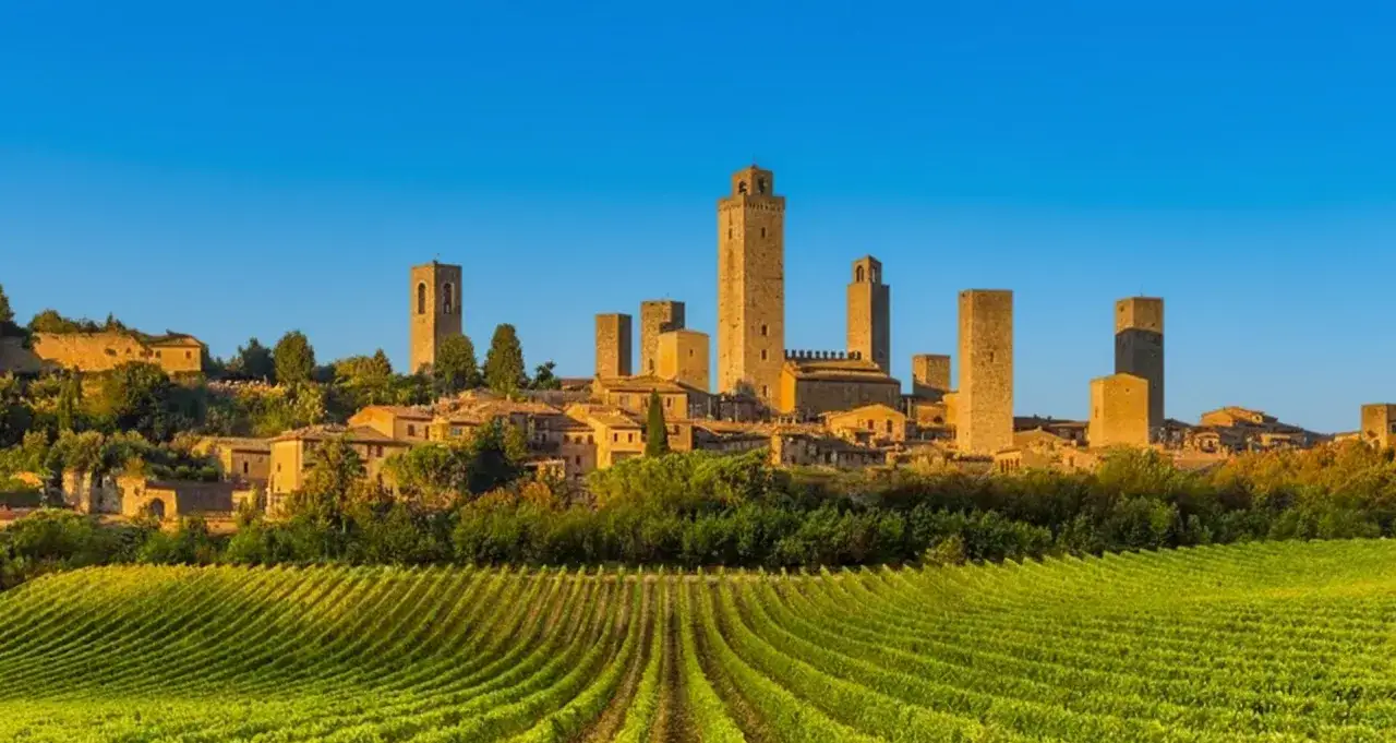 San Gimignano, gioiello medievale in provincia di Siena, con le sue torri svettanti su un paesaggio di vigneti rigogliosi.