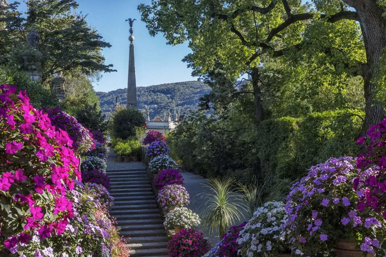 Giardini lussureggianti su un'isola, con scale fiorite e un obelisco. Un'isola bella cosa vedere, piena di colori vivaci e vegetazione rigogliosa.