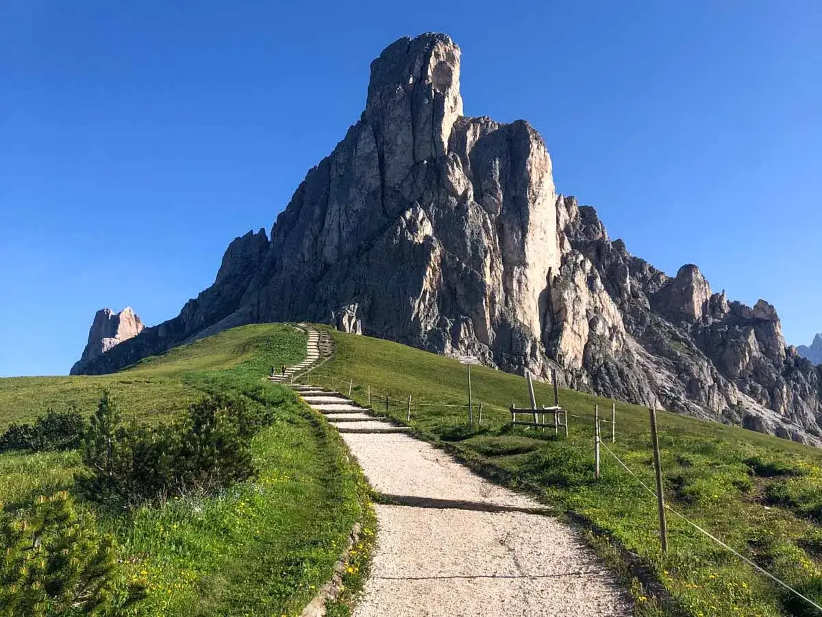 Sentiero che sale verso imponenti vette rocciose, ideale per passo Giau escursioni.