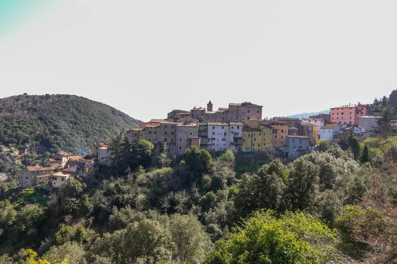 Borgo collinare con case colorate e tetti in cotto, immerso nel verde. Sassetta cosa vedere: un incantevole panorama.