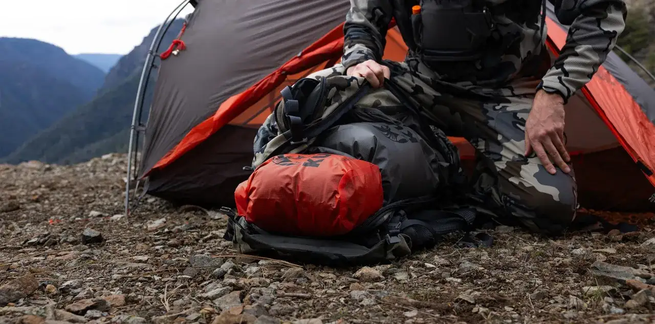 Preparazione per un'avventura: cosa mettere nello zaino per 3 giorni. Tenda e attrezzatura da campeggio su terreno roccioso.