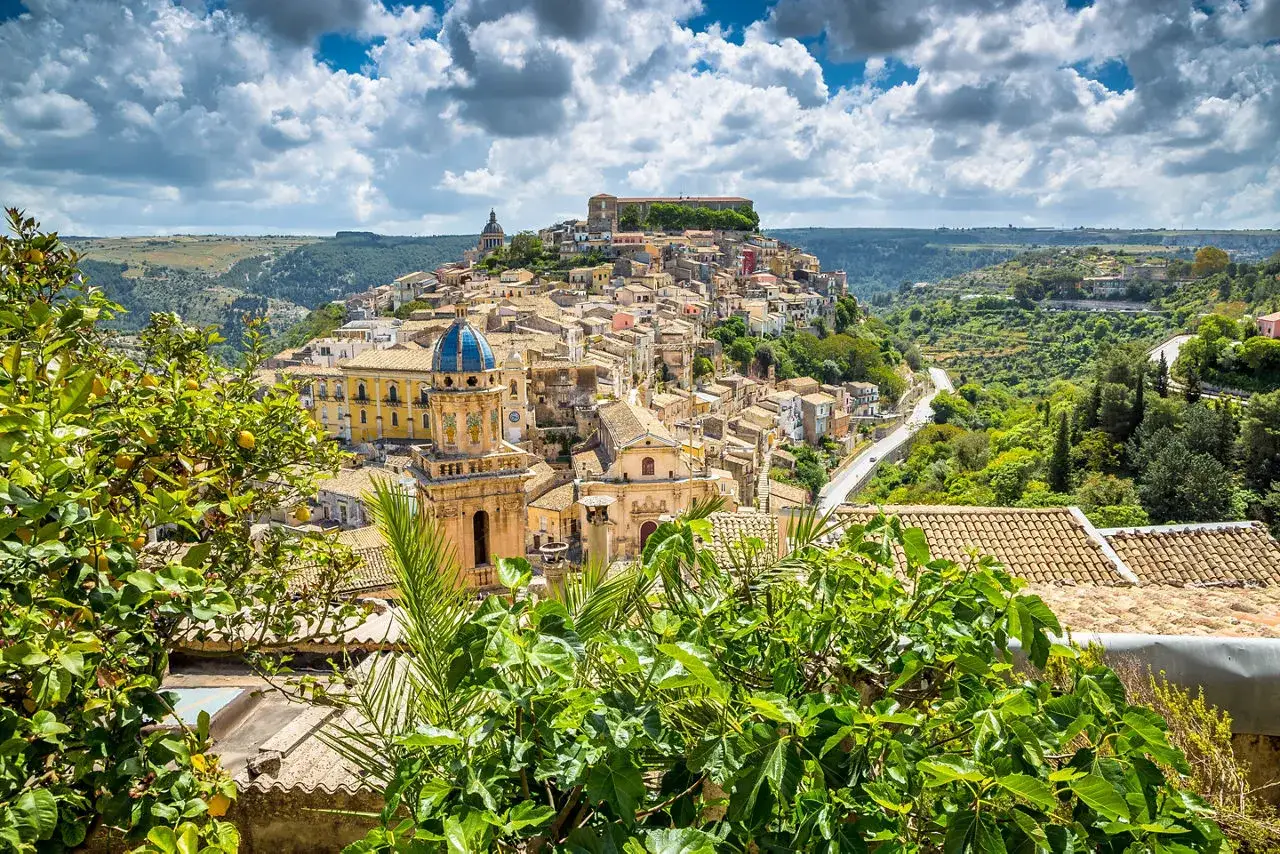Panoramica di un noto borgo della costiera amalfitana, con case arroccate su una collina e una chiesa dalla cupola blu.