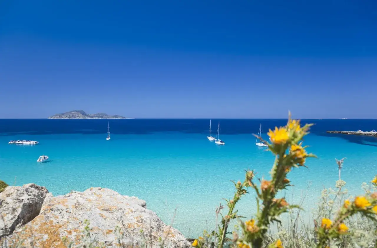 Acque cristalline e velieri solcano il mare tra Sicilia e Sardegna.