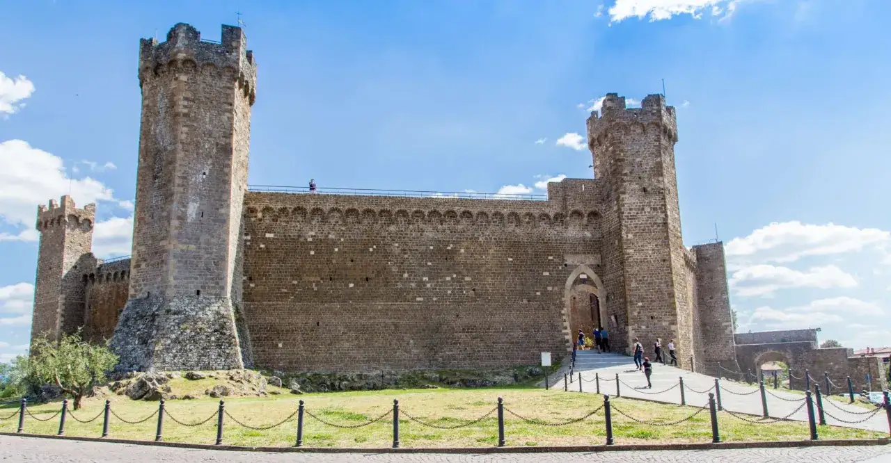 Fortezza di Montalcino, un luogo imperdibile per scoprire cosa vedere in un giorno. Imponente castello con torri e mura in pietra sotto un cielo azzurro.