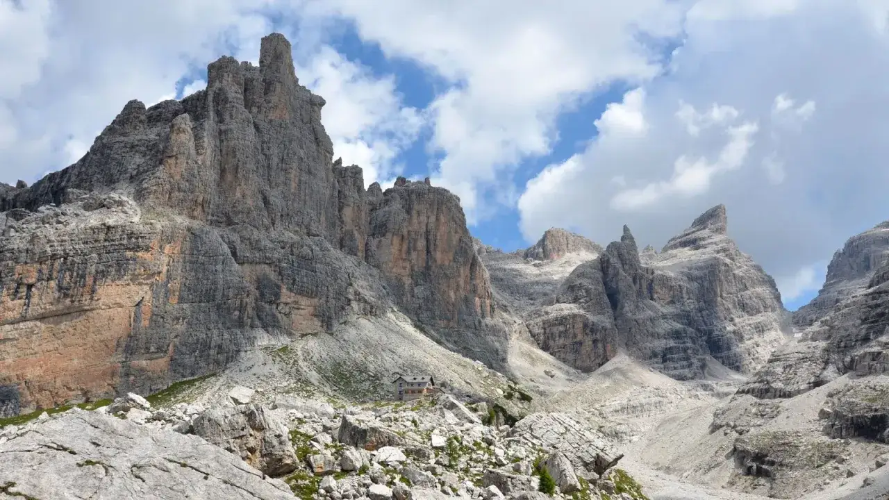 Rifugio alpino incastonato tra imponenti vette rocciose, ideale per escursioni in Alto Adige.