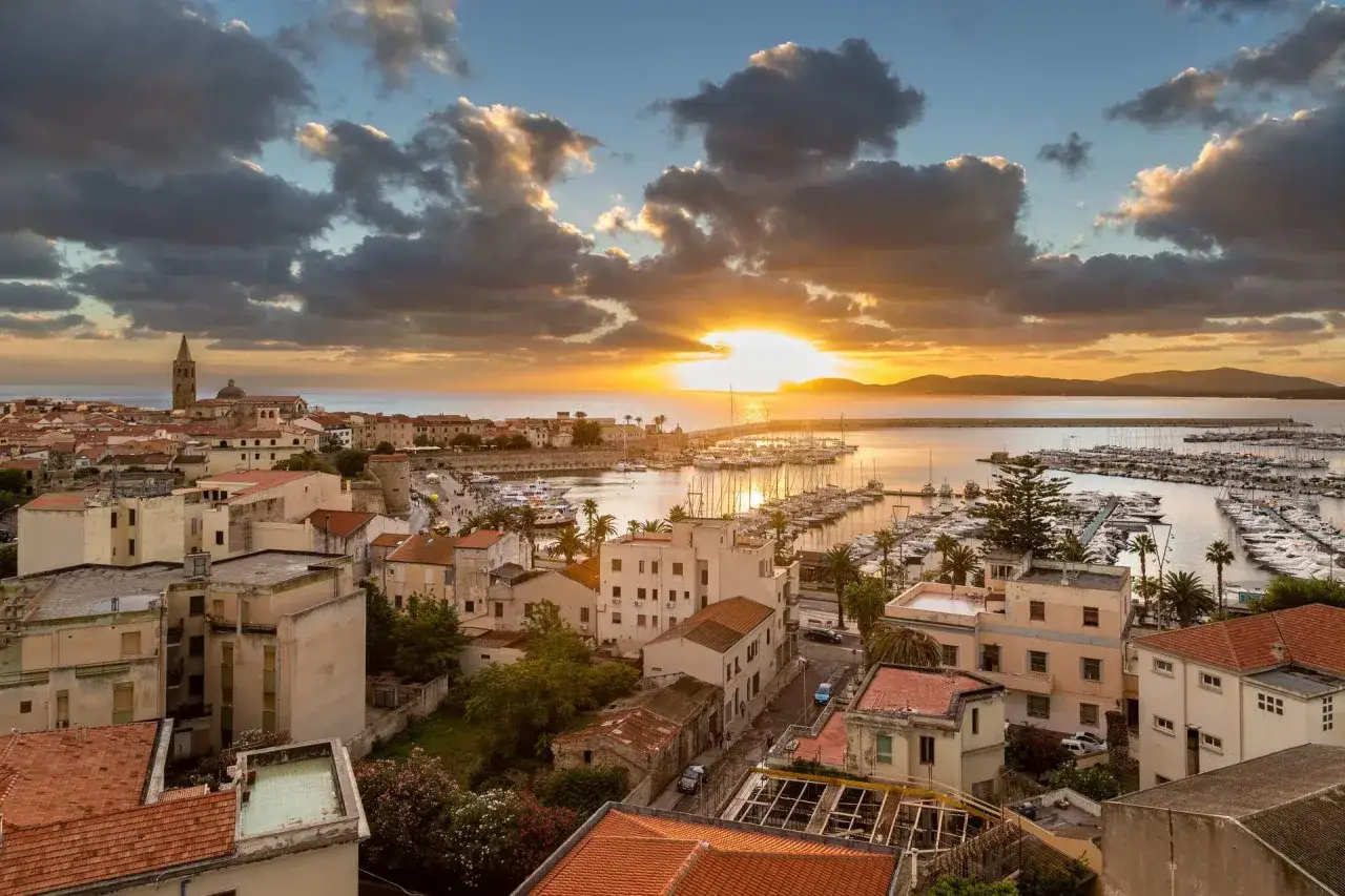 Tramonto su Alghero, con il porto turistico pieno di barche. Un'ottima vista per pianificare cosa vedere ad Alghero in 3 giorni.