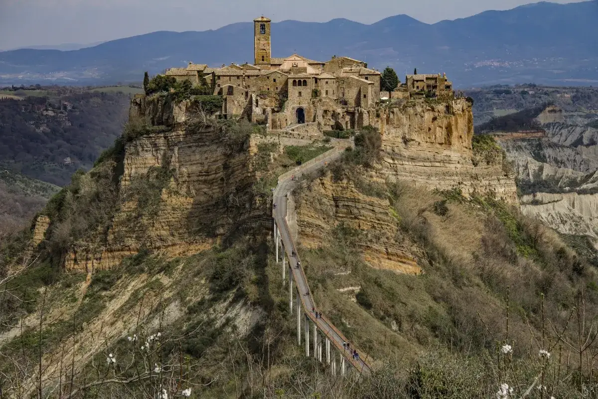 Un incantevole borgo medievale vicino Roma, arroccato su una rupe tufacea, raggiungibile tramite un suggestivo ponte pedonale.