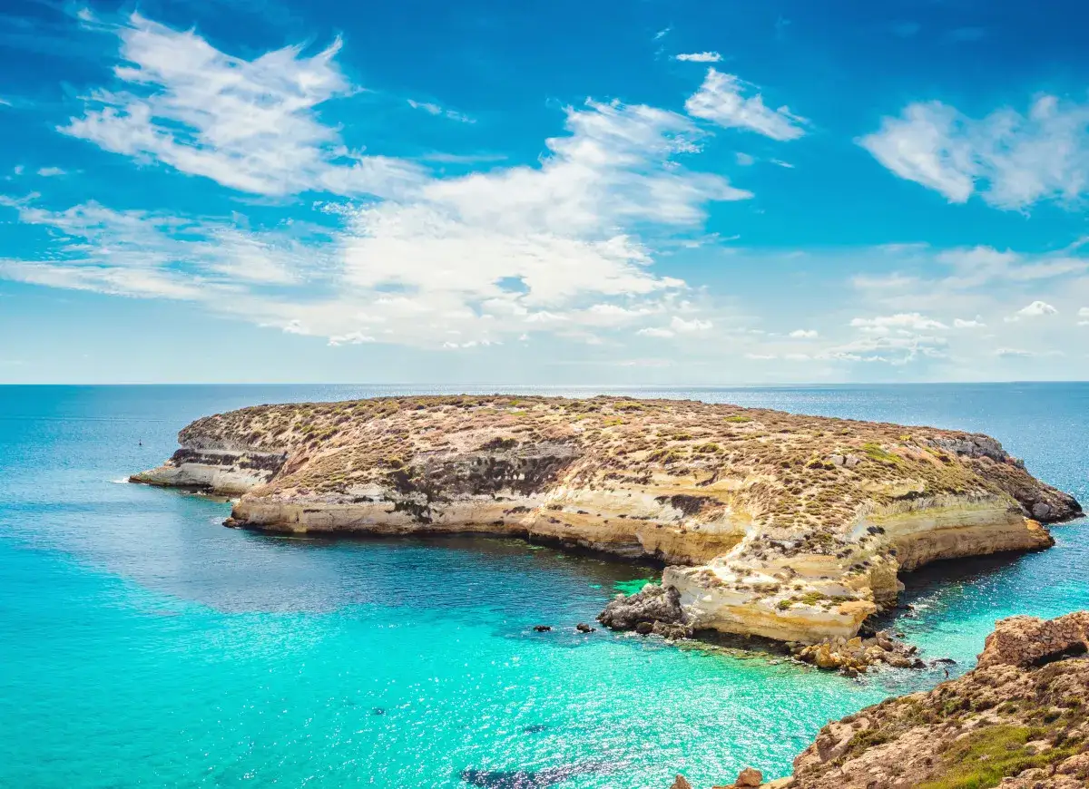 Isola presso Lampedusa, con acque cristalline e cielo azzurro. Un paradiso naturale.